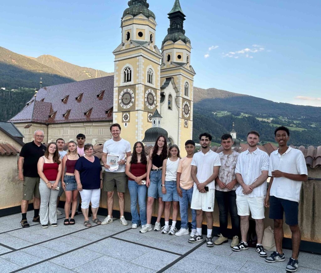 Ein Gruppenfoto von Jugendlichen in Brixen. Eine Person hält ein Dokument mit dem BSJ-Logo in der Hand.