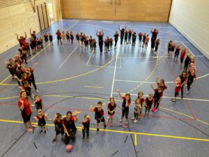 Turnkinder und Trainer vom TuS Teublitz bilden in der Turnhalle stehend ein Herz.