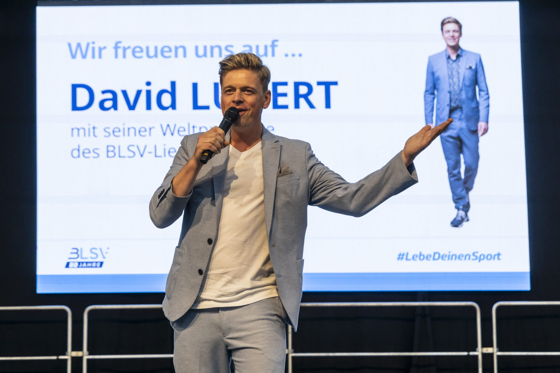 Er rockte die Bühne in der Sportschule Oberhaching: David Lugert heizte mit seinem Song "Lebe deinen Sport" den Gästen bei über 30°C nochmal zusätzlich ein. Der Song geht ins Ohr.