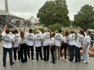 Personen stehen mit dem Rücken zur Kamera und zeigen alle in dieselbe Richtung