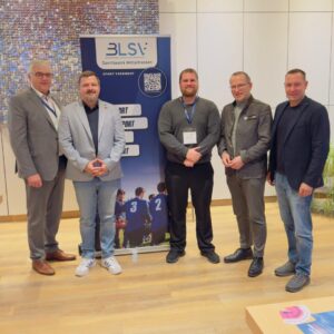 Eine Gruppe Menschen stehen vor einem aufgebauten Roll-Up mit dem BLSV Logo